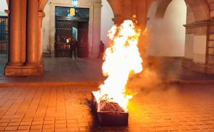 Familia del activista Eugui Roy prenden fuego a un ataúd frente al palacio de gobierno en la ciudad de Oaxaca
