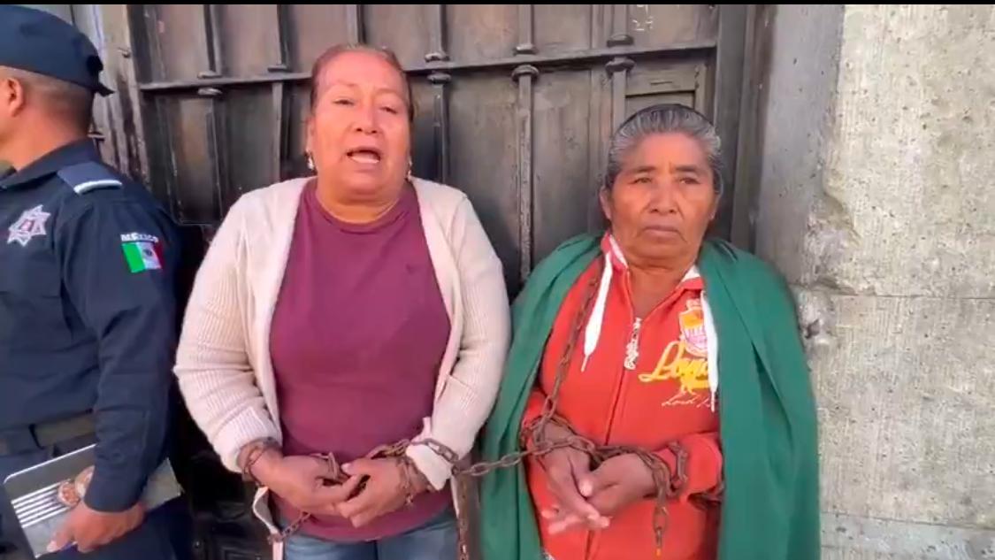 Dos mujeres se encadenan frente al palacio de gobierno en la ciudad de Oaxaca. Fotos: Especiales