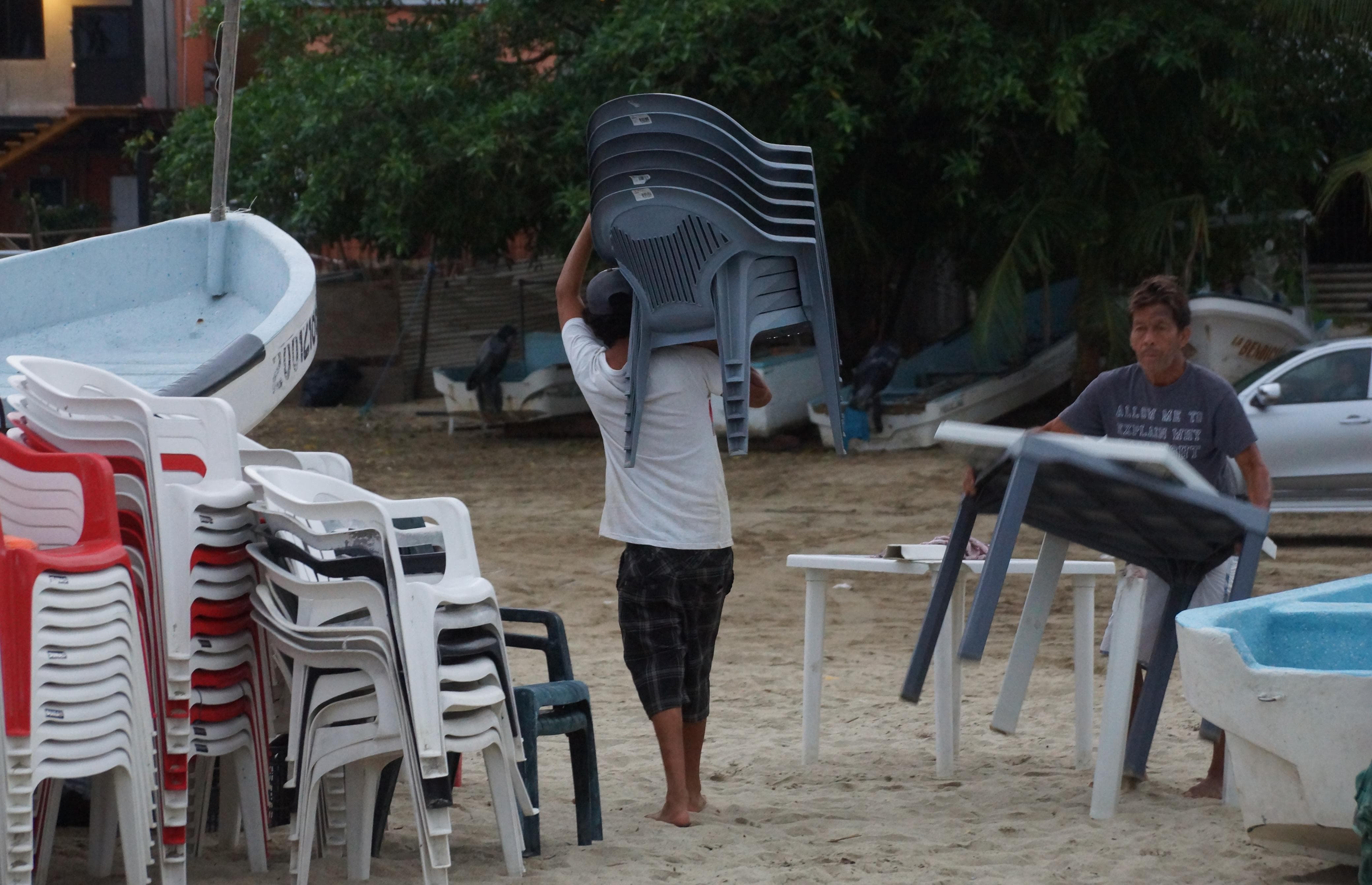 Restaurantes resguardan su mobiliario, ante el impacto del huracán Erick