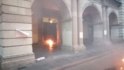 Normalistas prenden fuego a puerta del palacio de gobierno de Oaxaca