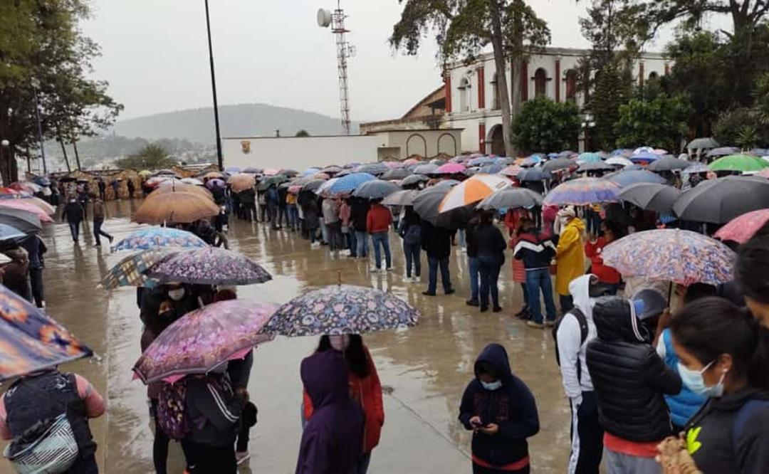 Miles de jóvenes esperan vacuna bajo la lluvia en Tlaxiaco, Oaxaca; mal clima impidió transportación aérea